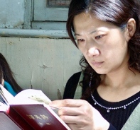 Chinesische Frau liest die Bibel